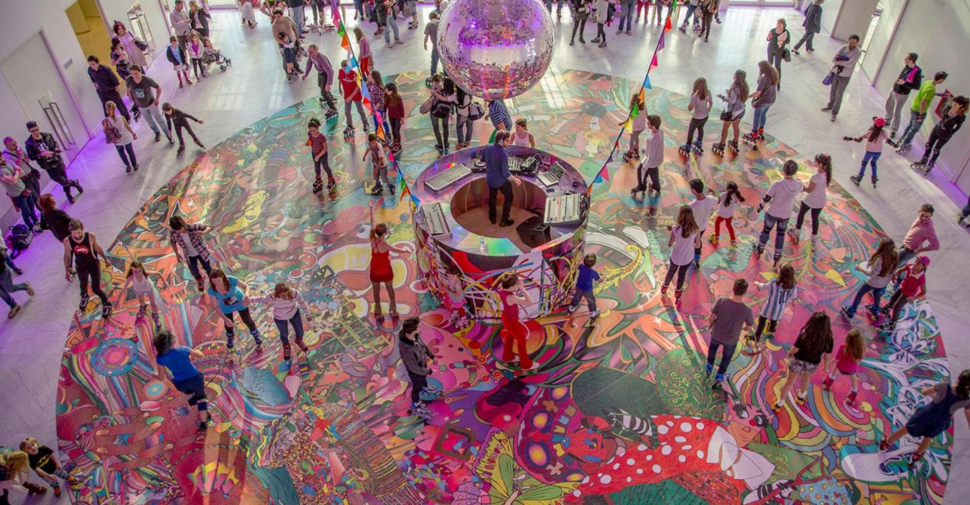 interior view of crowd of people dancing and roller skating with bright, vivid colors